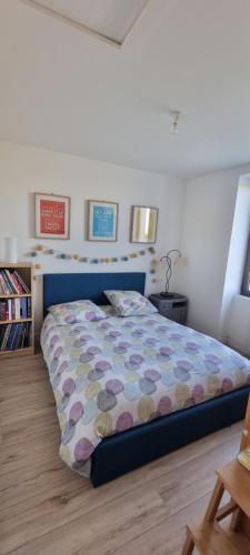 une chambre avec un lit avec une couette colorée dans l'établissement Longère typique à 2 km de la mer, à Pornic