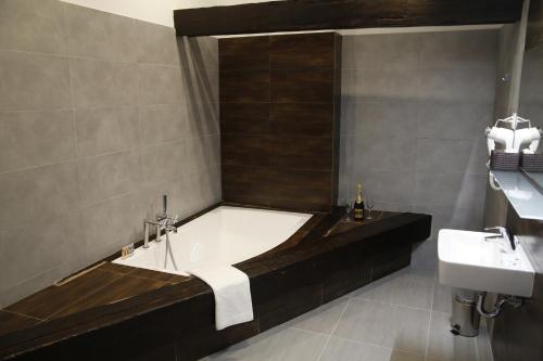 a bathroom with a bath tub and a sink at Hotel Chopin Bydgoszcz in Bydgoszcz