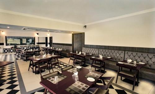 a restaurant with tables and chairs in a room at Mayur Belgaum Presidency Hotel & Spa in Belgaum