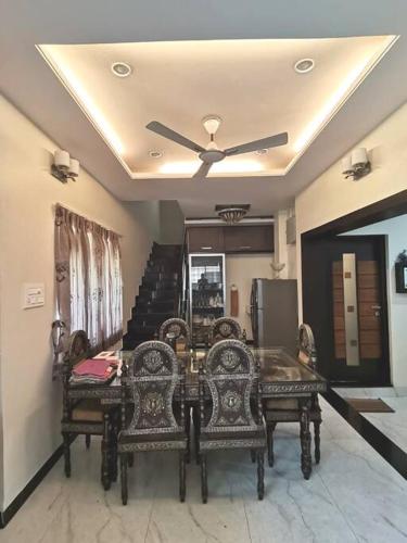 a dining room with a ceiling fan and a table and chairs at OM SHAKTI in Belgaum