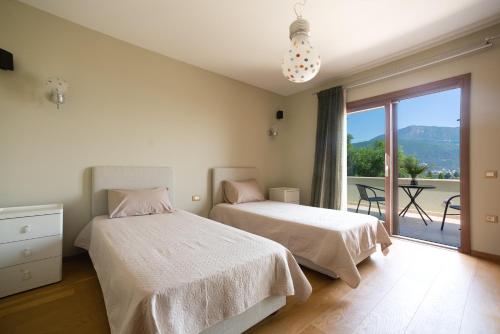 una camera da letto con due letti e un balcone di Villa Oneirodromio a Kato Korakiana