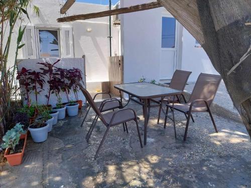une table et des chaises sur une terrasse agrémentée de plantes dans l'établissement SOUVLIA BEACH, à Parasporos