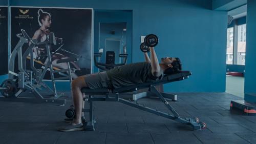 a woman laying on a bench in a gym at Mayur Belgaum Presidency Hotel & Spa in Belgaum