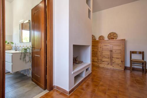 przedpokój z kominkiem i drewnianymi drzwiami w obiekcie Spacious home in Costa Rossa w mieście Trinità dʼAgultu