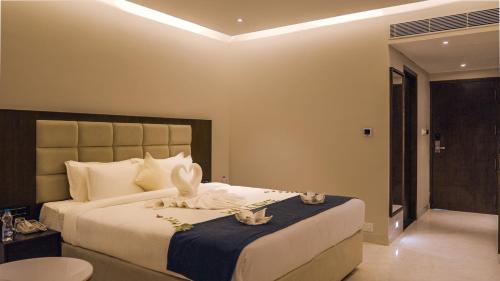 a bedroom with a large bed with towels on it at Mayur Belgaum Presidency Hotel & Spa in Belgaum