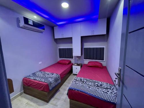 two beds in a room with a blue ceiling at Porto Golf Marina Alamein in El Alamein