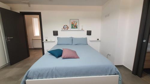 メンフィにあるVilletta Elmaのベッドルーム1室(大型ベッド1台、青とピンクの枕付)