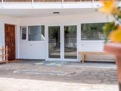 a porch with sliding glass doors and a bench at Casa con jardin para familias y grupos in Tegueste