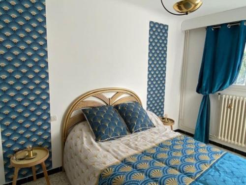 a bedroom with a blue and white bed and blue curtains at Une pause au paradis in Sorgues