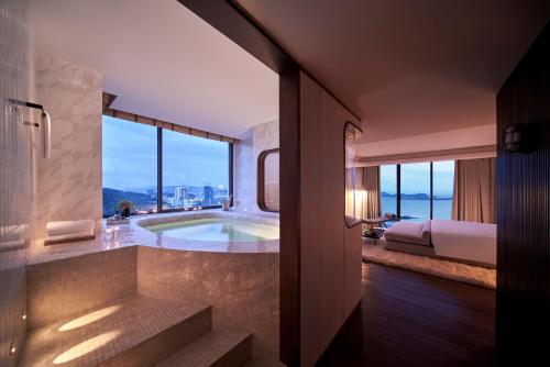 a bathroom with a tub with a view of the city at The Yacht Hotel by DC in Ha Long