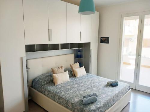 1 dormitorio con 1 cama grande y armarios blancos en Luxury home near the Beach private parking space, en Alghero