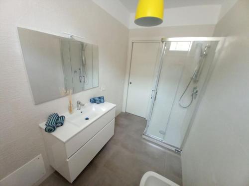 a white bathroom with a shower and a sink at Luxury home near the Beach private parking space in Alghero