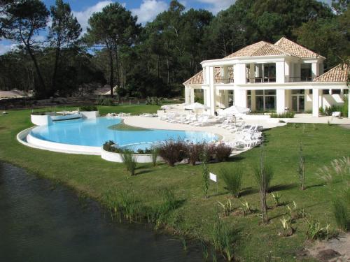 dom z basenem obok rzeki w obiekcie Green Park en Punta del Este w mieście Punta del Este