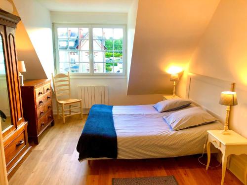 une chambre avec un lit et deux lampes et une fenêtre dans l'établissement L'Appartement de la Plage, à Saint-Quay-Portrieux