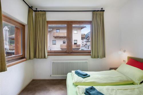 una camera con due letti e una finestra di Mele Baitel li Pigna a Livigno