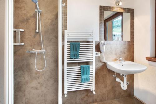 a bathroom with a shower and a sink and a mirror at Mele Baitel li Pigna in Livigno