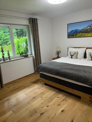 ein Schlafzimmer mit einem großen Bett und zwei Fenstern in der Unterkunft Haus Colorado am Gaisberg in Scheffau am Wilden Kaiser