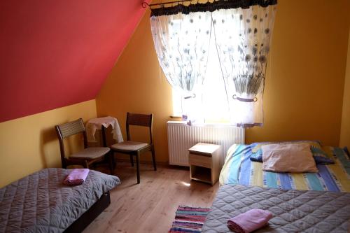 1 Schlafzimmer mit 2 Betten, einem Fenster und Stühlen in der Unterkunft Gospodarstwo Agroturystyczne Ćmilówka 