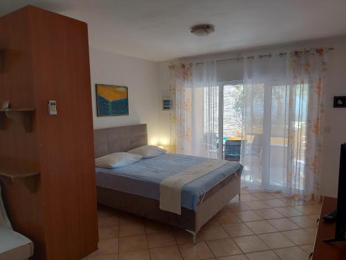 a bedroom with a bed and a large window at Apartment Vivoda in Štinjan