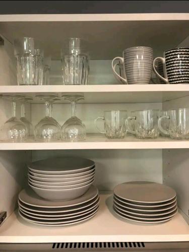 une étagère remplie d'assiettes, de tasses et de plats dans l'établissement Charmant Studio-Lyon 3éme, à Lyon