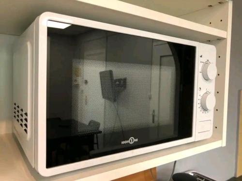 Un four micro-ondes est installé au-dessus d'une table. dans l'établissement Charmant Studio-Lyon 3éme, à Lyon