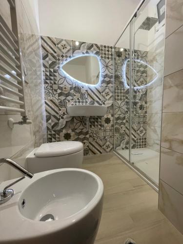 a bathroom with a sink and a toilet and a mirror at La Finestra sul Borgo in Campomarino