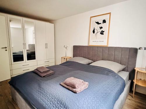 una camera da letto con un letto blu con due asciugamani di Der Stader Hafenblick a Stade