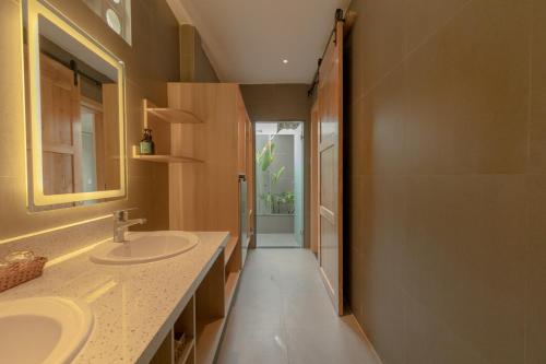 a bathroom with two sinks and a shower at Tây Tiến Bungalow in Phú Quốc