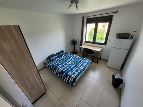 Schlafzimmer mit einem Bett, einem Schreibtisch und einem Fenster in der Unterkunft Résidence de la gare, chambre meublée in Longjumeau