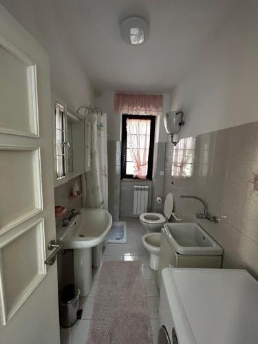 a white bathroom with two toilets and a sink and a toilet istg at Da Concy in Fossacesia