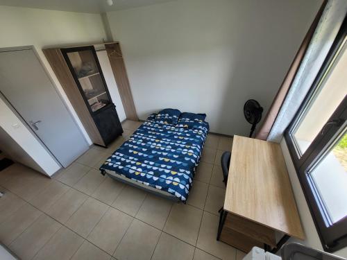 een kleine slaapkamer met een bed in een kamer bij Résidence de la gare, chambre meublée in Longjumeau
