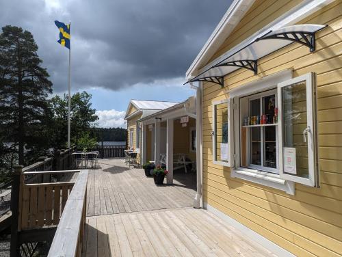 a building with a deck with a flag on it at Vårhaga Vandrarhem in Sjuntorp