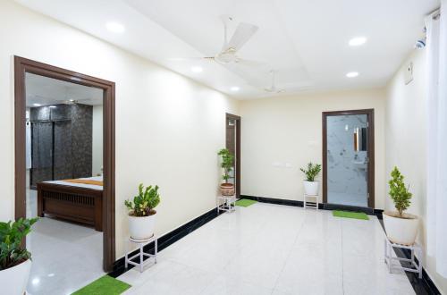 an empty room with plants and a mirror at Hotel Voila Atnest Suites Kokapet, Business Hotel in Hyderabad