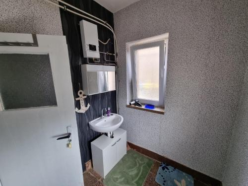 a bathroom with a sink and a window at Gästewohnung in der Nähe des Ferienparks Plötzky in Plötzky