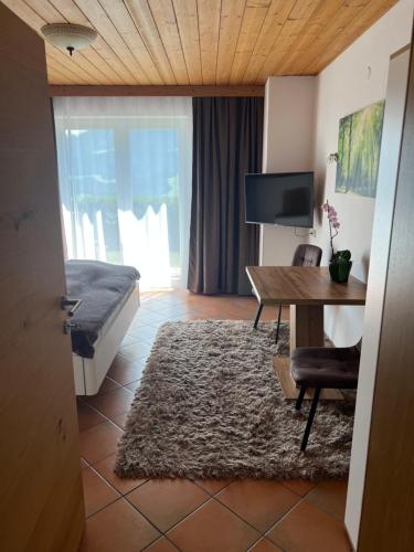 a room with a desk and a bed and a table at Haus Colorado am Gaisberg in Scheffau am Wilden Kaiser