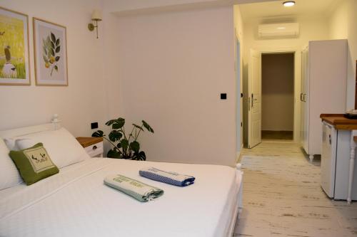 a bedroom with a white bed with two books on it at Maslin Otel in Gokceada Town