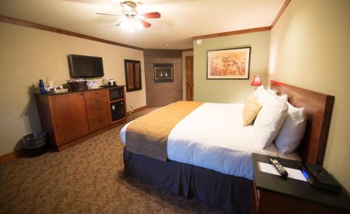 a hotel room with a bed and a flat screen tv at Avalon Lodge South Lake Tahoe in South Lake Tahoe