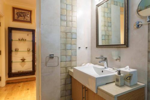 ein Bad mit einem Waschbecken und einem Spiegel in der Unterkunft Raman Villa, Shimla, amã Stays & Trails in Shimla