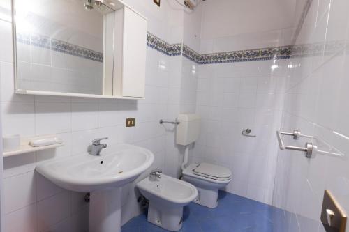 ein weißes Bad mit einem Waschbecken und einem WC in der Unterkunft La Dimora di William Casa nel centro storico di Desenzano in Desenzano del Garda