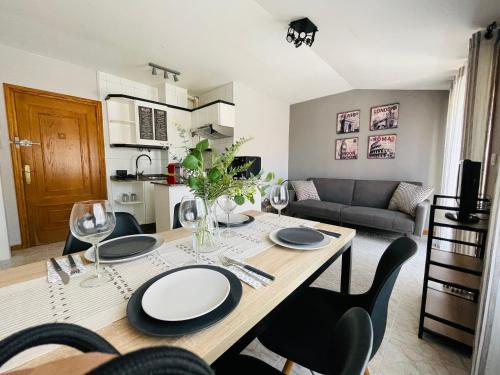 a dining room and living room with a table and chairs at El Apartamento de la Colegiata in Vigo