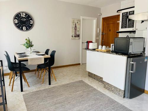 El Apartamento de la Colegiata في فيغو: مطبخ وغرفة طعام مع طاولة وثلاجة