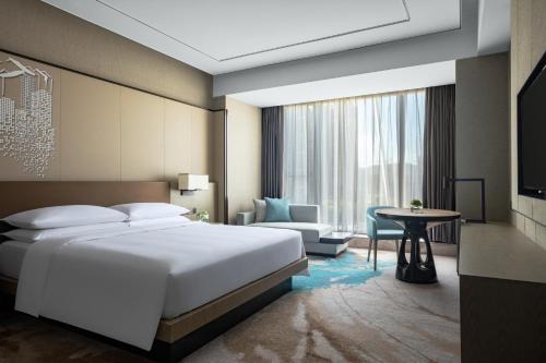 a hotel room with a bed and a table at Hangzhou Marriott Hotel Lin'an in Lin'an