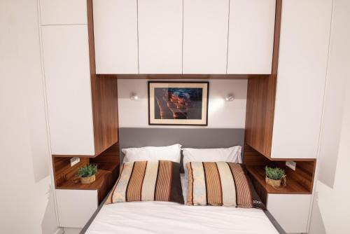 a bedroom with a bed and white cabinets at Canta Amore Suites in Zadar
