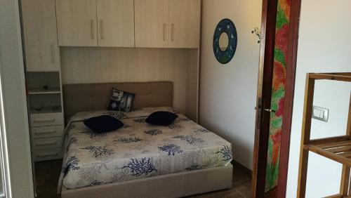 1 dormitorio con 1 cama con 2 almohadas en Villa Relax tra gli Ulivi, en Alghero