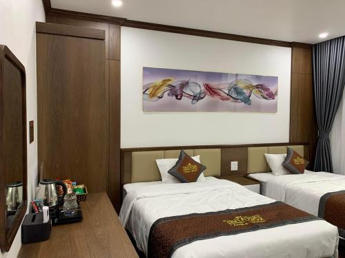 um quarto de hotel com duas camas e um quadro na parede em Anika Hotel em Ha Long