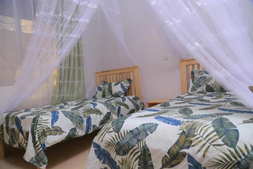 two beds sitting next to each other in a bedroom at The Junction Apartments in Mbarara