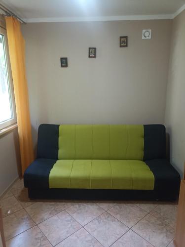 a green couch in a room with a window at Domek Letniskowy nad zaporą Rożnowską in Rożnów