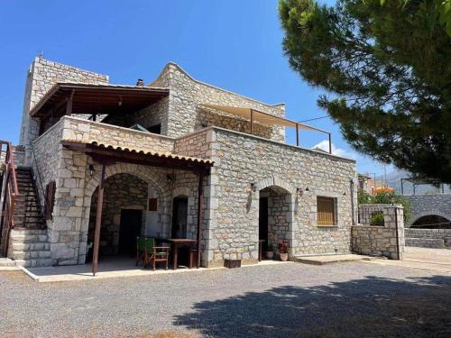 a stone house with a balcony on top of it at Torre di Maina in Kharoúdha