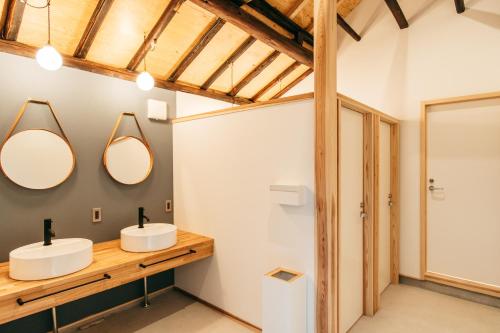 La salle de bains est pourvue de 2 lavabos et de 2 miroirs. dans l'établissement Yado Charinko, à Gose
