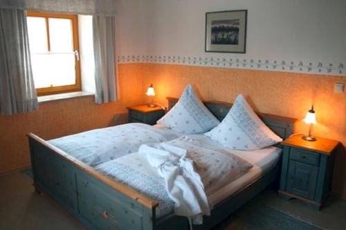 ein Schlafzimmer mit einem Bett mit zwei Nachttischen und einem Fenster in der Unterkunft Ferienhof Veit 